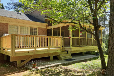 Imagen de terraza de estilo de casa de campo extra grande en patio trasero con barandilla de madera