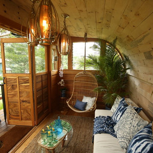 Immagine di un piccolo soggiorno tropicale chiuso con pareti beige, pavimento in legno massello medio, nessun camino, nessuna TV e pavimento marrone