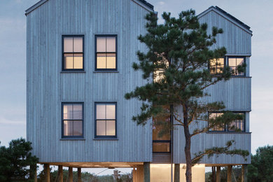 Coastal beige three-story wood exterior home idea in Portland Maine with a metal roof