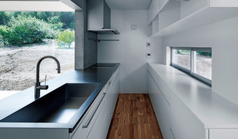 白い扉とモルタル、ステンレスのコンビネーションが美しい