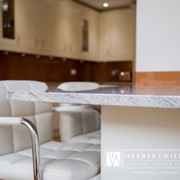 Ivory Mackintosh kitchen with stunning copper glass splashback