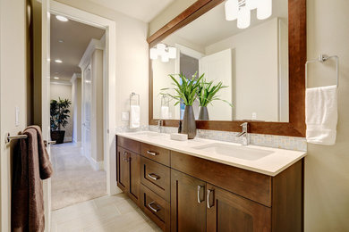 Mid-sized master ceramic tile porcelain tile and white floor bathroom photo in DC Metro with recessed-panel cabinets, brown cabinets, a two-piece toilet, white walls, an undermount sink, quartz countertops, a hinged shower door and white countertops