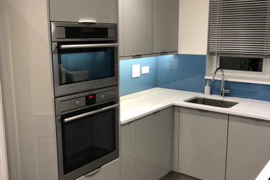 Inspiration for a small modern grey and white galley kitchen/diner in Other with a submerged sink, flat-panel cabinets, grey cabinets, quartz worktops, blue splashback, engineered quartz splashback, ceramic flooring, no island, grey floors and white worktops.