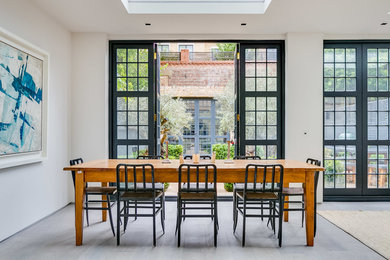 Design ideas for a large scandi dining room in London with beige walls, light hardwood flooring and grey floors.