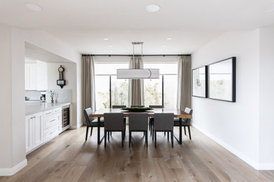 Example of a mid-sized transitional medium tone wood floor and brown floor kitchen/dining room combo design in Phoenix with white walls and no fireplace
