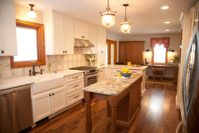 Design ideas for a mid-sized traditional u-shaped eat-in kitchen in Minneapolis with a farmhouse sink, shaker cabinets, white cabinets, granite benchtops, multi-coloured splashback, ceramic splashback, stainless steel appliances, dark hardwood floors, with island and brown floor.