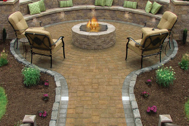 This is an example of a large traditional backyard patio in Providence with natural stone pavers and no cover.