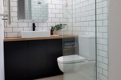 Inspiration for a small contemporary 3/4 bathroom in Melbourne with flat-panel cabinets, grey cabinets, a corner shower, a one-piece toilet, white tile, ceramic tile, white walls, ceramic floors, a trough sink, wood benchtops, beige floor, a hinged shower door and beige benchtops.