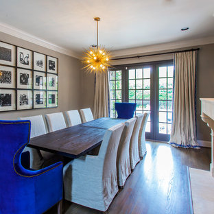 Inspiration pour une grande salle à manger ouverte sur le salon bohème avec un mur gris, un sol en bois brun, une cheminée standard et un manteau de cheminée en plâtre.