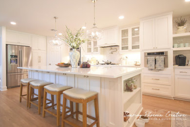 Example of a mid-sized transitional u-shaped laminate floor and brown floor eat-in kitchen design in Austin with an undermount sink, raised-panel cabinets, white cabinets, quartz countertops, white backsplash, subway tile backsplash, stainless steel appliances, an island and white countertops