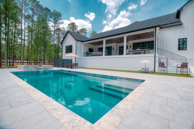 Foto de piscina rectangular en patio trasero con suelo de baldosas