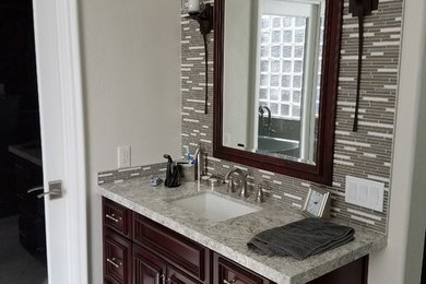 Example of a mid-sized transitional master gray tile and matchstick tile marble floor and white floor bathroom design in Las Vegas with recessed-panel cabinets, medium tone wood cabinets, gray walls, an undermount sink and marble countertops