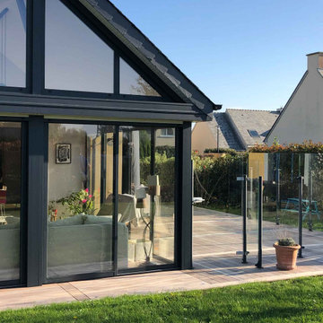 Agrandissement d'une terrasse en bois exotique avec un pare-vent en verre