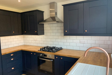 Design ideas for a medium sized traditional u-shaped kitchen in Devon with shaker cabinets, blue cabinets, wood worktops and ceramic splashback.