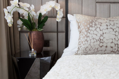 Inspiration for a large modern master and grey and black bedroom in Surrey with beige walls, dark hardwood flooring, no fireplace, brown floors, a coffered ceiling, panelled walls and feature lighting.