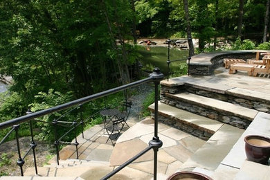 Design ideas for a mid-sized transitional backyard patio in Burlington with natural stone pavers and no cover.