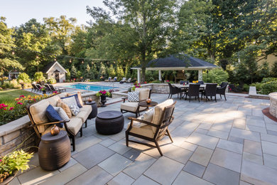 Patio - huge contemporary backyard stone patio idea in Chicago with a fireplace