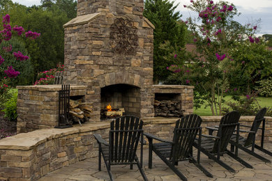 Inspiration for a mid-sized traditional backyard patio in Other with a fire feature, natural stone pavers and no cover.