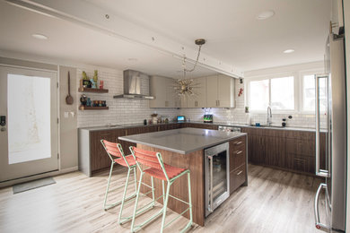 Large mid-century modern u-shaped laminate floor and beige floor eat-in kitchen photo in New York with an undermount sink, flat-panel cabinets, brown cabinets, quartz countertops, white backsplash, subway tile backsplash, stainless steel appliances, an island and gray countertops