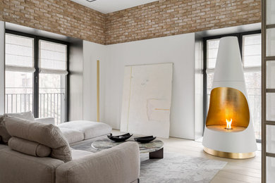 Living room - contemporary open concept light wood floor, beige floor and brick wall living room idea in San Diego with white walls