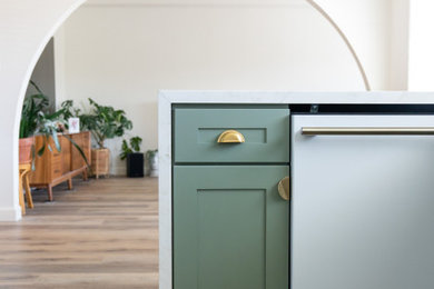 Example of a mid-sized 1950s u-shaped vinyl floor and brown floor eat-in kitchen design in Los Angeles with an undermount sink, shaker cabinets, green cabinets, marble countertops, white backsplash, subway tile backsplash, white appliances, a peninsula and multicolored countertops