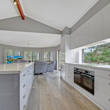 Open plan style kitchen with glass splashback window