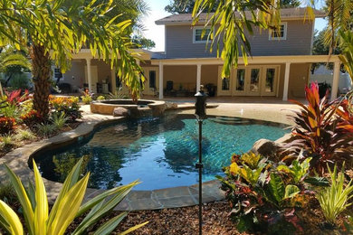 Mid-sized backyard tile and kidney-shaped natural hot tub photo in Tampa