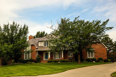 Large modern two-storey brick red exterior in Wichita with a hip roof.