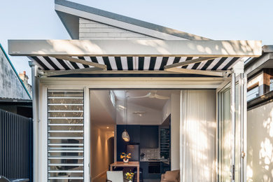 Inspiration pour une petite façade de maison blanche design en brique de plain-pied avec un toit en métal et un toit gris.