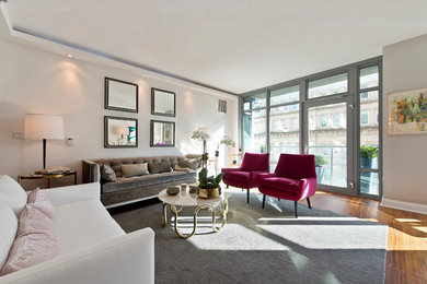 Transitional medium tone wood floor living room photo in New York with beige walls