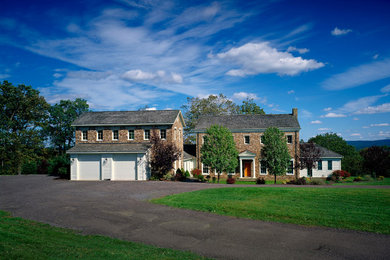 Example of a large cottage white two-story stone exterior home design in Other