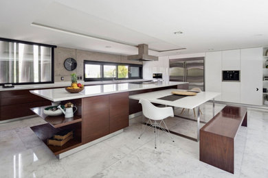 Large contemporary l-shaped separate kitchen in New York with flat-panel cabinets, white cabinets, quartz benchtops, grey splashback, cement tile splashback, stainless steel appliances, marble floors, with island and white floor.
