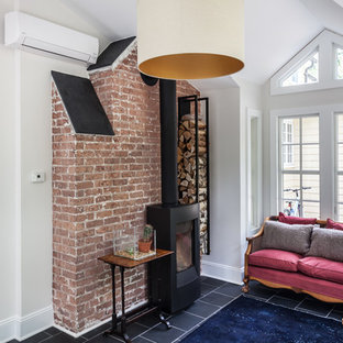 Klassisk inredning av ett mellanstort hemmastudio, med grå väggar, skiffergolv, en öppen vedspis och ett fristående skrivbord