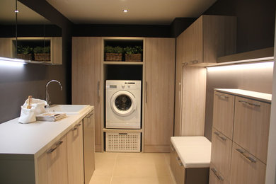 Esempio di una lavanderia multiuso minimal di medie dimensioni con ante lisce, pareti grigie, pavimento in gres porcellanato e pavimento beige