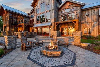 Inspiration for a huge rustic backyard stone patio remodel in Milwaukee