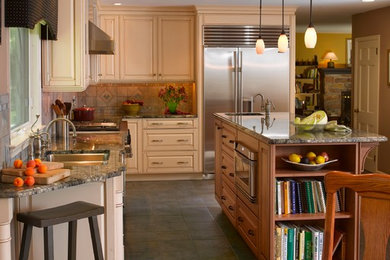 Example of a mid-sized classic l-shaped slate floor eat-in kitchen design in Philadelphia with an undermount sink, raised-panel cabinets, stainless steel appliances, an island, light wood cabinets, granite countertops, beige backsplash and ceramic backsplash