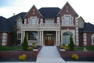 Large tuscan two-story brick exterior home photo in Oklahoma City