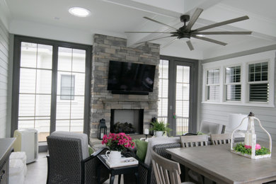 Large arts and crafts vinyl floor and beige floor sunroom photo in Louisville with a stacked stone fireplace and a skylight