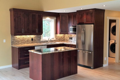 Open concept kitchen - small eclectic l-shaped light wood floor open concept kitchen idea in Calgary with an undermount sink, dark wood cabinets, granite countertops, matchstick tile backsplash, stainless steel appliances, an island, recessed-panel cabinets and multicolored backsplash