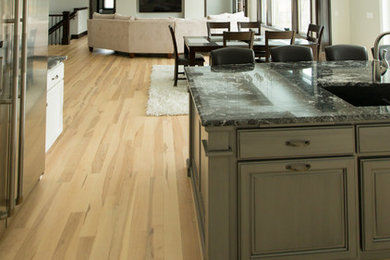 Mid-sized elegant u-shaped light wood floor and beige floor open concept kitchen photo in Other with shaker cabinets, white cabinets, an island, quartz countertops and stainless steel appliances