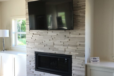 Example of a mid-sized trendy open concept medium tone wood floor and brown floor family room design with beige walls, a standard fireplace, a stone fireplace and no tv