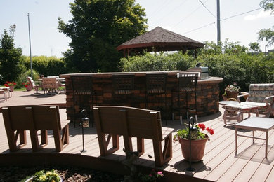 Inspiration for a large craftsman backyard patio kitchen remodel in Other with decking and a gazebo
