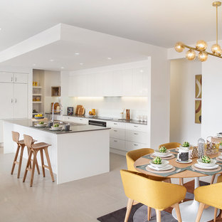 Inspiration pour une grande arrière-cuisine parallèle vintage avec un évier 2 bacs, un placard à porte shaker, des portes de placard blanches, un plan de travail en granite, une crédence blanche, une crédence en carrelage métro, un électroménager en acier inoxydable, un sol en carreaux de ciment, un îlot central, un sol beige et un plan de travail gris.