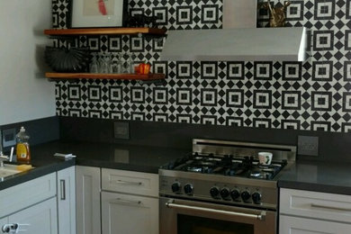 Example of an eclectic l-shaped medium tone wood floor eat-in kitchen design in San Diego with raised-panel cabinets, white cabinets, granite countertops, white backsplash, ceramic backsplash, stainless steel appliances and no island