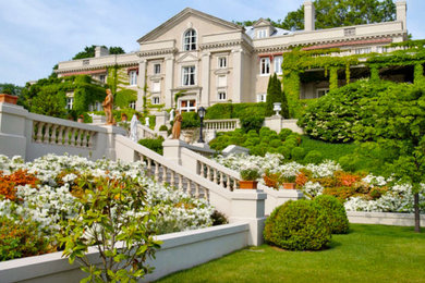 Example of a huge tuscan beige two-story exterior home design in New York