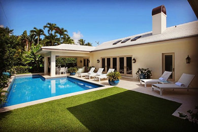 Design ideas for a mid-sized modern backyard l-shaped pool in Miami with natural stone pavers.