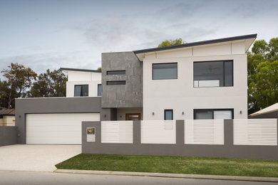 Large modern two-storey grey house exterior in Perth with stone veneer, a butterfly roof and a metal roof.