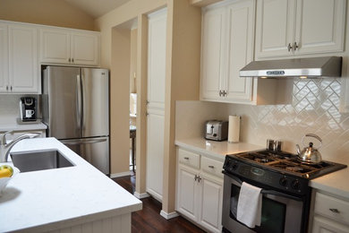 Eat-in kitchen - mid-sized contemporary l-shaped dark wood floor eat-in kitchen idea in Sacramento with a single-bowl sink, raised-panel cabinets, white cabinets, quartz countertops, white backsplash, subway tile backsplash, stainless steel appliances and an island