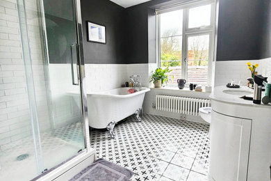 Design ideas for a large traditional bathroom in Gloucestershire with shaker cabinets, white cabinets, a claw-foot bath, a corner shower, a one-piece toilet, white tiles, porcelain tiles, black walls, porcelain flooring, an integrated sink, multi-coloured floors, a sliding door, white worktops, a single sink and a freestanding vanity unit.