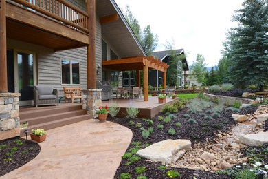 Design ideas for a mid-sized country backyard patio in Salt Lake City with a water feature, decking and a pergola.